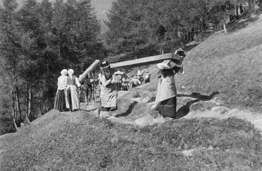 Foto Männer und Frauen, Greise und Kinder helfen beim Tragen mit