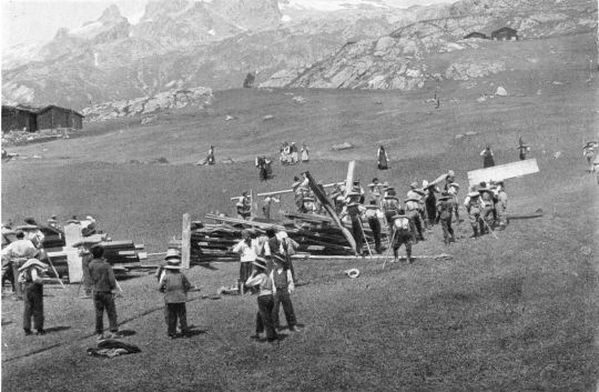 Foto Männer und Frauen, Greise und Kinder helfen beim Tragen mit